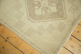 Distressed ivory and beige pile, geometric border, and secured edge of vintage Oushak rug.