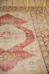 Distressed vintage Oushak carpet pile showing even wear, light foundation, muted reds, and sand.