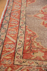 Distressed Oushak rug detail: pale cherry red vine border with ivory, worn field, and selvage.