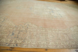 Distressed vintage Oushak rug; soft blush, ivory, and pale blue motifs with even wear.