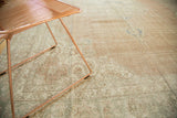 Distressed vintage Oushak rug's textural detail, faded blush, ivory, and pale blue.