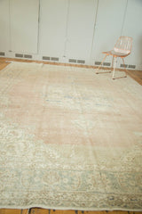 Textured pile of a distressed Oushak rug showing blush, ivory, and pale blue wear.