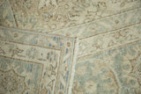 Distressed vintage Oushak rug with even wear, soft blush, ivory, and seafoam blue curvilinear patterns, and short fringe.