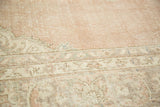 Distressed vintage Oushak rug pile with pale blush and ivory floral border.