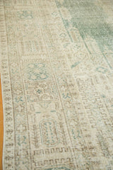 Faded beige, brown, and muted green geometric patterns on a distressed Oushak rug.