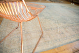 Faded rococo-style arabesques and floral bouquets on a distressed vintage Oushak rug.