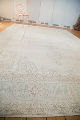 Faded curvilinear patterns and distressed ivory tones on this vintage Turkish Oushak carpet.