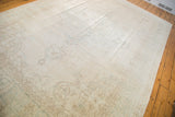 Decorative vintage distressed Oushak carpet displaying its soft ivory field and subtle faded brown motifs.