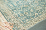 Traditional distressed Oushak carpet showing faded ocean blue-green palmette and lotus flowers.