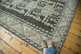 Visible abrashes and geometric floral patterns on a charcoal and beige distressed Kula carpet.