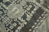 Textured close-up of distressed Kula rug, showing gray geometric motifs and beautiful abrashes.