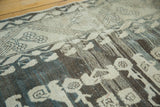 Artfully distressed vintage Kula carpet texture, showcasing muted charcoal, gray, and beige variations.