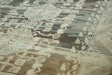 Distressed Kula carpet with textural abrashes, muted geometric floral patterns in charcoal, beige, gray.