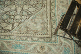 Distressed vintage Persian Mahal rug corner with beige, charcoal, and teal Herati pattern.