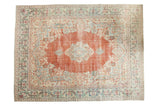 Distressed vintage Arak carpet featuring a terra cotta floral medallion, soft blues, and ivory, 10'x13'3