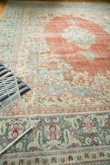 Distressed Arak carpet border with budding flowers, teal and vivid rust tones.