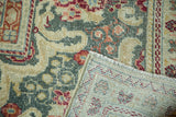 Distressed Arak carpet detail: worn floral pile in pale gold, teal, rust, and foundation.