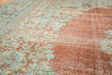 Vintage Arak carpet detail: distressed rust and pale blue floral pattern, with visible foundation.