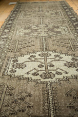 Detailed view of the vintage Persian runner’s floral medallion with vinery in gray and antique ivory.