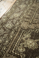Hand-knotted Persian rug with vinery and tendril motifs, showing even pile wear in gray and ivory.