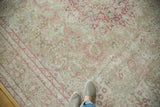 Low-pile texture of a distressed Persian carpet with raspberry, sand, and powder blue floral details.