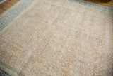 Distressed blush and ivory field texture with sky blue motifs and intricate blue border.