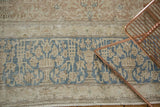 Powder blue vase and vine motifs on a distressed vintage Meshed carpet border, with fringe.