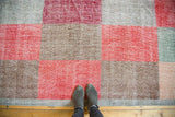 Distressed multi-paneled modern Oushak rug in faded cherry red, beige, and silver tones.