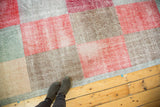 Distressed modern Oushak rug showing multi-paneled design with faded cherry red, ocean green, and sand.