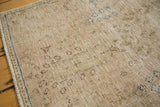 Distressed vintage Meshed rug texture with foundation showing, subtle beige and coffee brown tones, faint blue border.