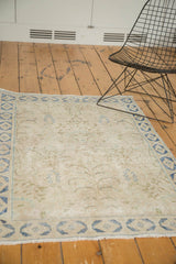 Distressed field and blue border with delicate patterns on a vintage Persian rug.