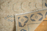 Distressed beige vintage Persian rug pile, showing even wear and the woven back with denim blue designs.