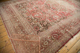 Intricate red, ivory, and brown Herati border details on a distressed vintage Tabriz rug.