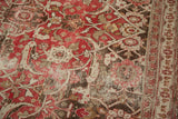 Vintage Persian Tabriz rug detail with distressed red, ivory, and brown Herati motif.