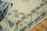 Distressed pile texture with faded dusty green meandering vine border on a vintage Oushak.