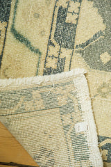 Distressed pile texture, hand-knotted reverse, and fringed edge of vintage Oushak rug.