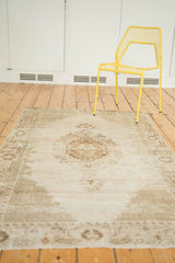 Vintage distressed Oushak rug's layered medallion, detailed lattice spandrels, and muted neutral colors.