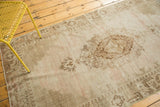 Intricate central medallion and lattice spandrels on a distressed Oushak rug, showing lightened pile.