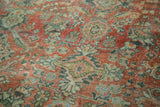 Distressed Mahal rug's curvilinear floral pattern: worn texture in terra cotta, teal, and antique ivory.