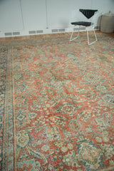 Distressed Mahal carpet's worn pile texture, featuring terra cotta, teal curvilinear floral patterns.