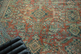 Distressed vintage Mahal carpet, close-up of curvilinear floral motifs in terra cotta, teal, and worn ivory.