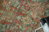 Distressed Mahal carpet's curvilinear floral motifs in terra cotta, teal, and ivory.