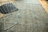 Distressed vintage Tabriz carpet showcasing worn blue and coffee brown floral patterns.