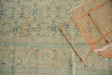 Evenly worn vintage Tabriz rug showing faded blue floral border and Herati field.