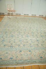 Distressed vintage Tabriz carpet border with scrolling vinery, floral motifs, and muted blue tones.