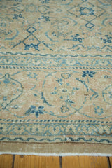 Distressed beige and blue floral vinery border on a vintage Tabriz carpet.