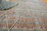 Distressed Meshed carpet showing ornate scrolling tendrils, pomegranate red, and sky blue border.