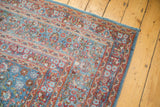 Corner detail of distressed Meshed carpet, intricate blue, red floral patterns, even wear.