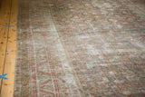 Faded blue, red, and ivory herati pattern on a distressed antique Malayer rug runner.