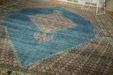 Distressed vintage Mahal rug detail, stepped blush floral spandrels on watery blue field.